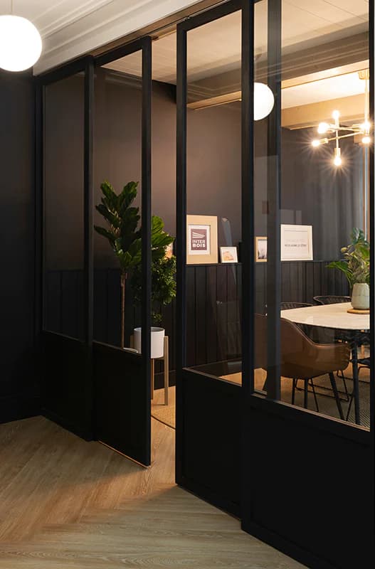 Verrière d’atelier en acier noir devant une salle de réunion